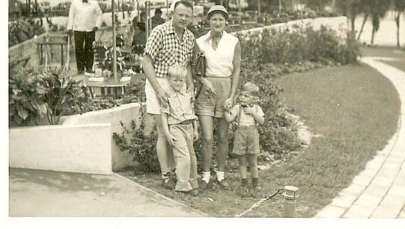A vintage photo of a family with two children posing outdoors.