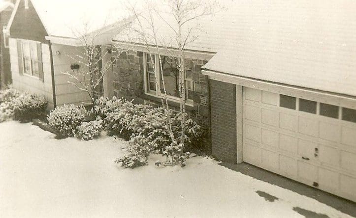 Snow-covered house and garage in winter.