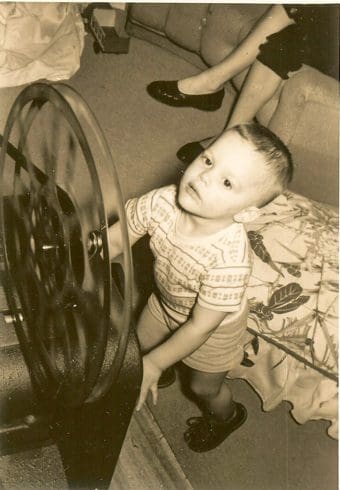 Child playing with a large spinning wheel.