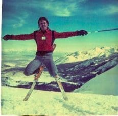 Skier jumping in snowy mountain landscape.