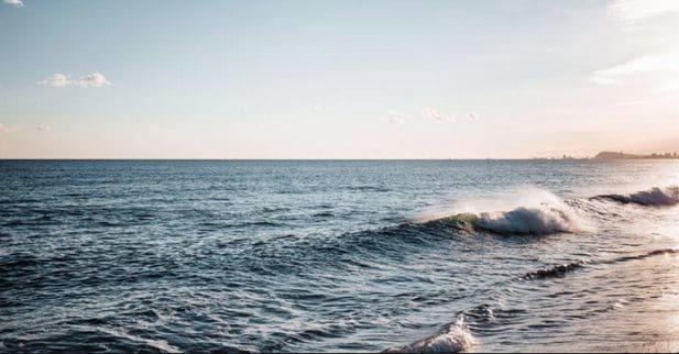 Ocean waves under a clear blue sky.
