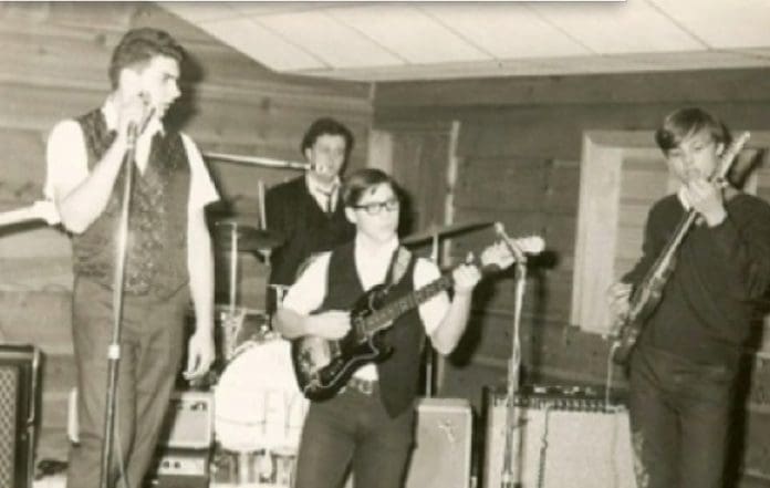 Band performing on stage in vintage setting.