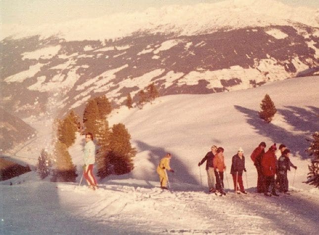 Group skiing on a snowy mountain slope.