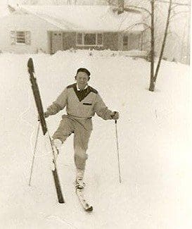 Person skiing in snowy yard near house.