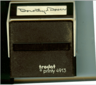 A vintage Trodat Printy 4913 stamp with a handwritten label on top.