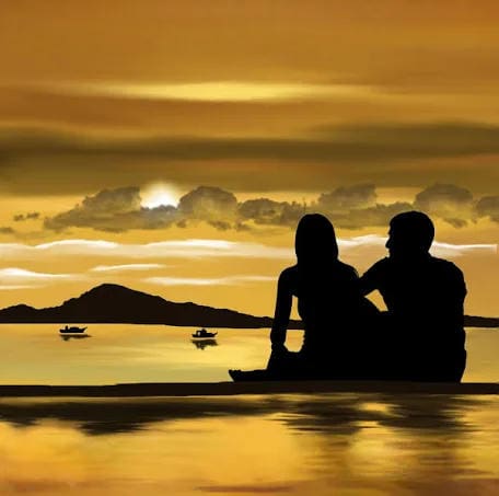 Silhouetted couple watching sunset by ocean.