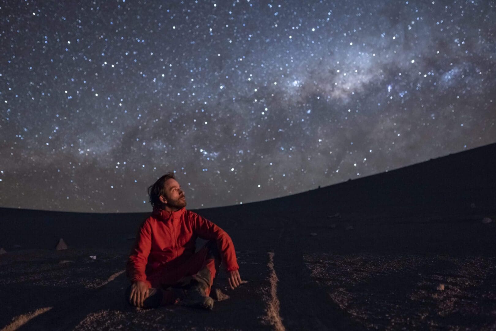 Man stargazing under a starry night sky.