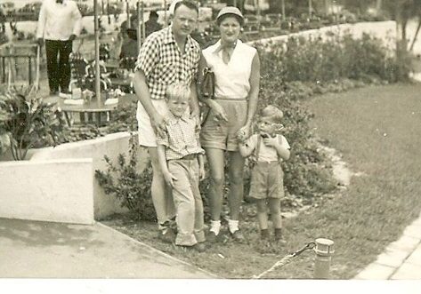A vintage photo of a family with two children posing outdoors.