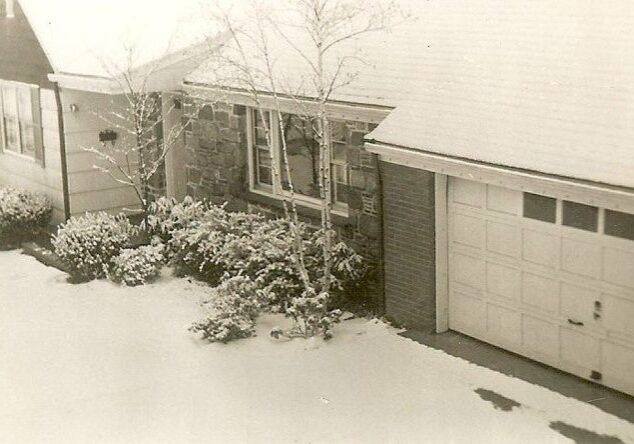 Snow-covered house and garage in winter.