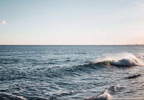 Ocean waves under a clear blue sky.