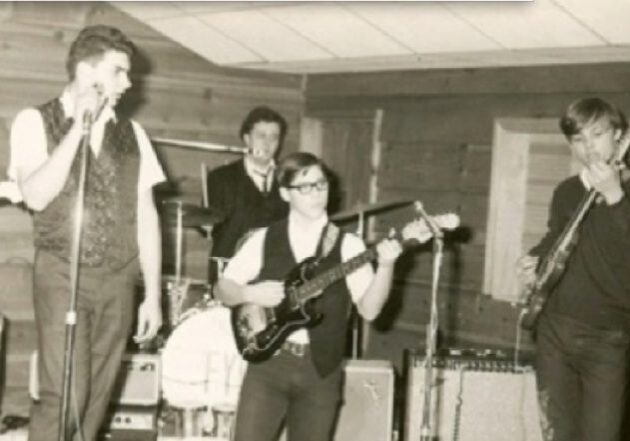 Band performing on stage in vintage setting.