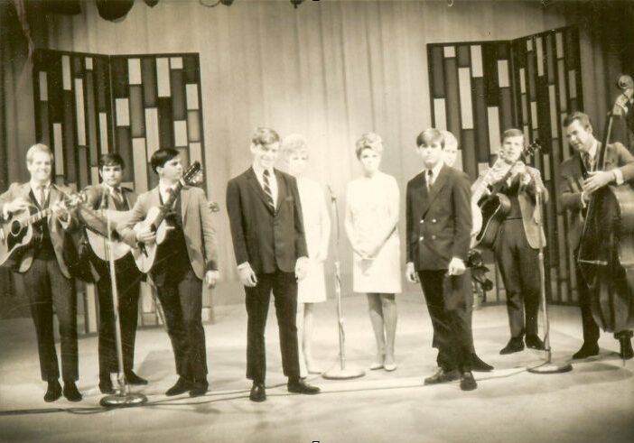 Band performing on stage with instruments, 1960s.